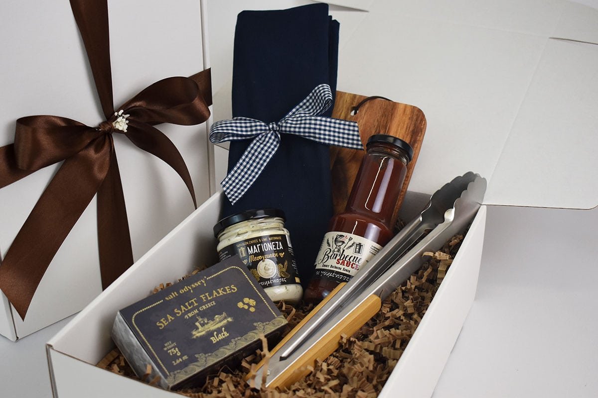 Fire & Flavor — Ξύλινη επιφάνεια, εργαλεία ψησίματος και συσκευασμένα γευστικά συνοδευτικά.